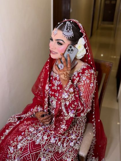 A candid moment of the bride on her Nikkah day. Her makeup looks fresh and flawless, with a beautiful floral hair accessory adding a touch of softness.