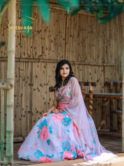 A lovely portrait in a rustic, bamboo-themed outdoor setting. The floral lehenga adds a touch of tradition to a modern photoshoot.