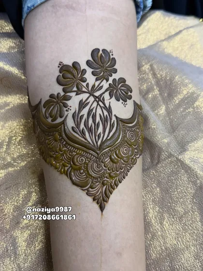 The completed floral bouquet armband, with intricate patterns filling the base. It's a beautiful fusion of bold florals and delicate traditional work.