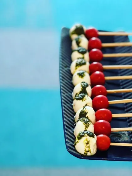 A poolside favorite: Caprese skewers with fresh mozzarella, cherry tomatoes, and a drizzle of basil pesto.