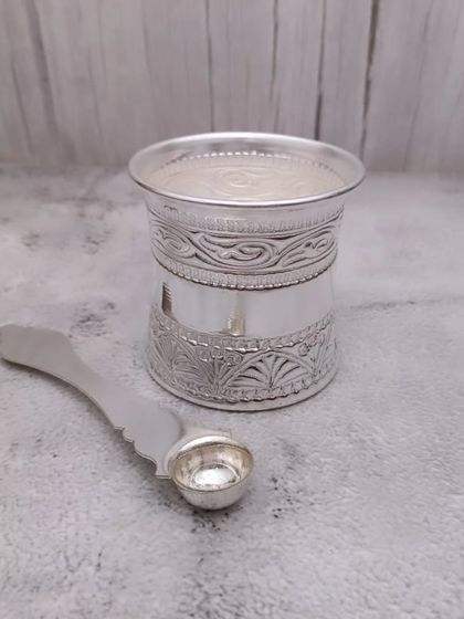 A German silver panchapatra set, including the glass and spoon (uddharani). This is an essential item for distributing holy water during pooja.