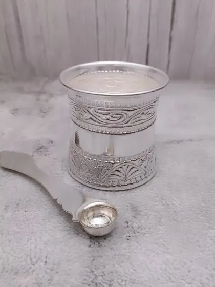 Another view of the German silver panchapatra set, highlighting the embossed patterns on the glass.