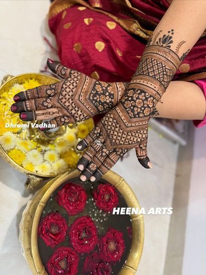 A beautifully composed shot of a traditional Indian mehendi design, with bowls of flowers adding to the festive feel.