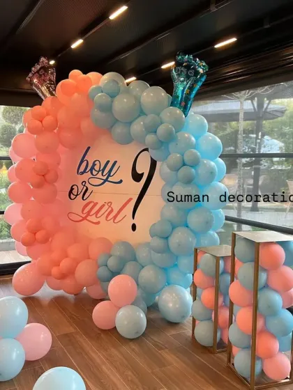 A classic "Boy or Girl?" gender reveal decoration. I used a circular backdrop with a balloon arch split between pink and blue to build excitement for the big reveal.