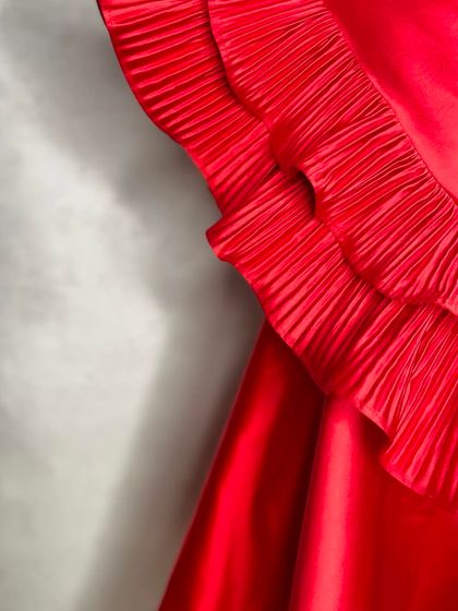 A close-up of the signature micro-pleated ruffles on our "Red Desire" dress. The craftsmanship in each fold creates a unique texture and volume.