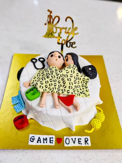 Game Over! A funny and kinky cake for a bride-to-be. This design shows a couple in a compromising position, surrounded by fun details, perfect for a bachelorette party that doesn't take itself too seriously.