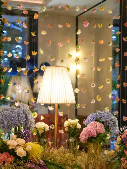 A whimsical detail of a curtain made from strings of delicate, colorful flowers. This created a beautiful, diffused light and added a touch of magic to the space.