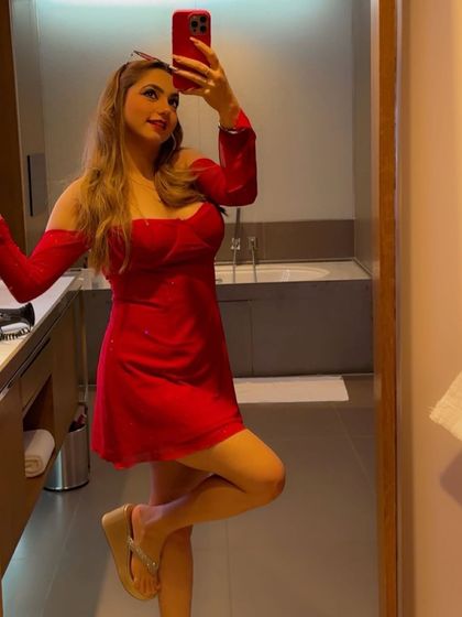 A full-length mirror selfie of the red mini dress, showing off the complete look with wedge sandals.
