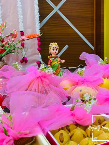 The details matter in a traditional ceremony. Here, we have arranged return gifts wrapped in bright pink tulle alongside a traditional Marapachi Bommai doll, adding a touch of cultural charm and color to the event.
