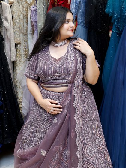 A side view of the violet lehenga, highlighting its texture and the way it drapes.