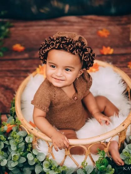 A bright smile from inside the cozy basket. These sessions are designed to be comfortable and engaging for the baby, resulting in natural and happy photos.