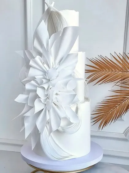 Imagine creating wedding cakes this elegant and flawless. This three-tiered white architectural cake showcases the modern wafer paper techniques and sharp edges you'll master in our advanced workshops.
