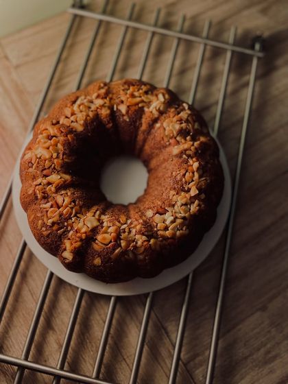 A simple and elegant banana cinnamon nuts bundt cake, cooling on a rack. The bundt shape gives every slice a lovely crust.
