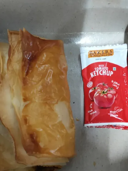 For lighter snack requirements, we provide packed snack boxes. This one contains a fresh vegetable puff pastry, perfect for a quick bite during a conference or workshop.