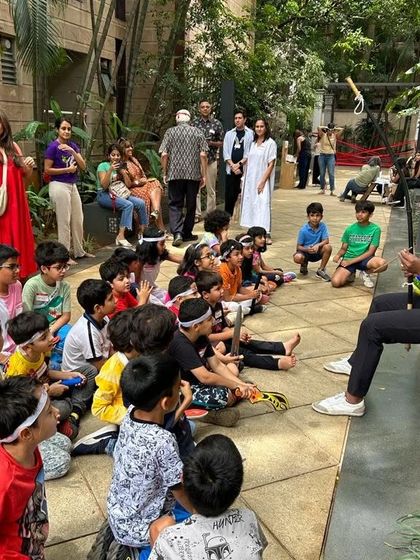 A group of children listen intently as an instructor explains the role of music in Capoeira during a weekend workshop.