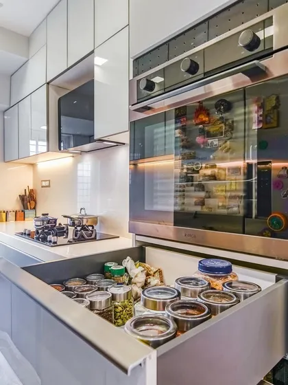 A deep drawer with customized compartments for storing spices and masala containers. This keeps everything upright and easy to find while cooking.