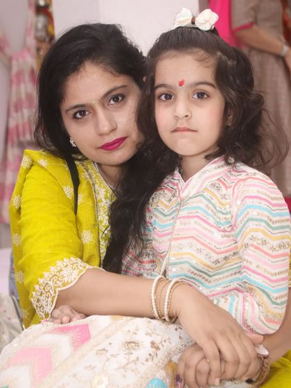 A mother and daughter share a quiet moment, posing for a close-up portrait.