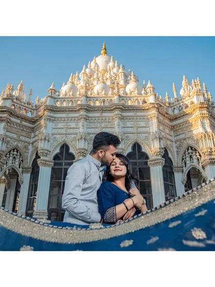 Weaving together love and location. This stunning pre-wedding photograph at a beautiful temple uses the bride's flowing saree to frame a perfect, romantic composition.