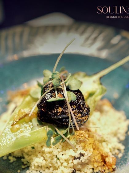 A beautifully plated dish featuring couscous topped with a stuffed chili and microgreens. This creation from a social affair at Nevaeh showcases our commitment to elegance and culinary excellence.