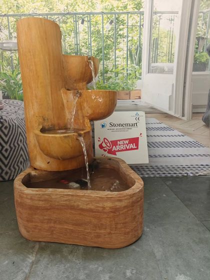 A Vastu-friendly cascading fountain carved from Teak Sandstone. The water flows down three tiers, creating a sound like a natural stream. At 32 inches tall, it's a great fit for a balcony or a quiet corner of a garden.