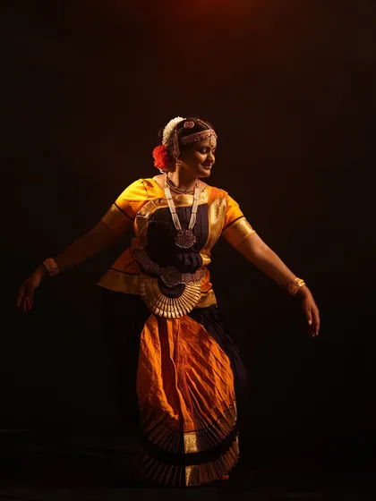 A graceful portrait of a Bharatanatyam dancer in mid-pose. I offer authentic classical dance costumes and jewelry for rent, captured with dramatic studio lighting.