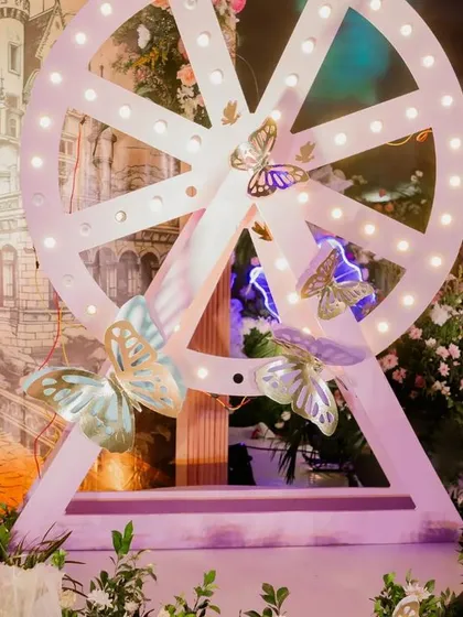 A custom-made, light-up Ferris wheel prop adds a touch of whimsy to this enchanted garden theme. Paired with a castle backdrop, it creates a perfect photo opportunity and enhances the fairytale setting.