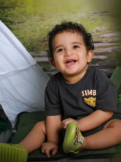A happy camper in our forest-themed studio. This little explorer's smile is as bright as a campfire, perfectly capturing the joy of adventure.