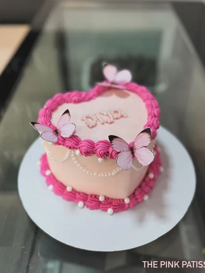 Another view of the heart-shaped butterfly cake, showing the delicate pearl details along the side.