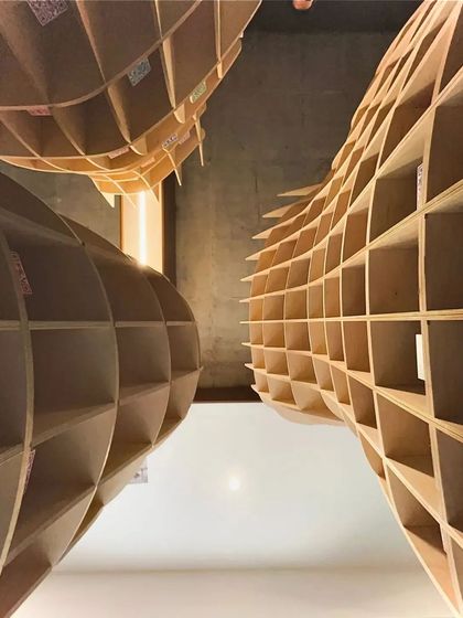 A worm's-eye view looking up through the 'Stradata' structures. This unusual angle highlights the project's sculptural and cellular nature, revealing the geometry that holds the entire form together.