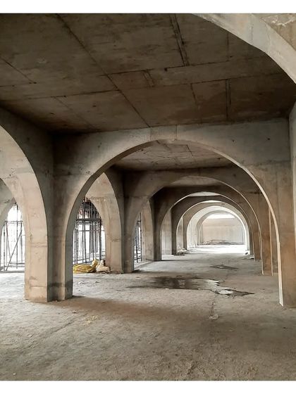 Another view of the concrete arches at Sanskriti Vihara. The lower floor meditation halls are below grade, opening onto a rainwater harvesting reservoir, connecting the spiritual space with the natural element of water.