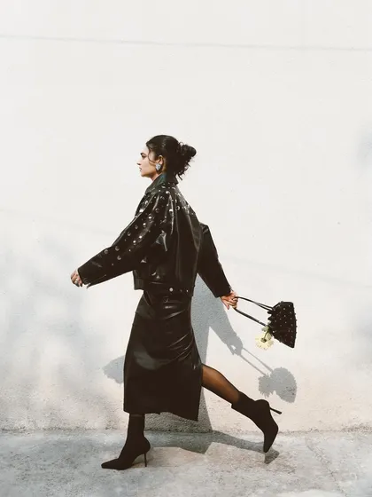 A side-profile shot of Kavya Trehan walking, creating a sense of movement and purpose. This is a classic street-style fashion shot that feels alive.
