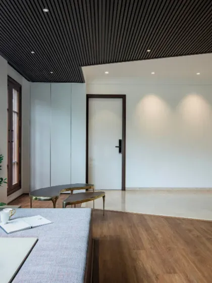 Another angle of the nature-centric lounge, highlighting the clean lines of the built-in seating and the contrast between the warm wood floor inlay and the cool polished tile. This space is a perfect example of a tranquil indoor retreat.