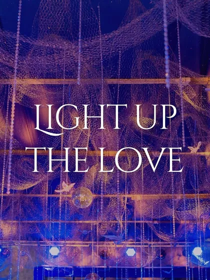 A video titled "Light Up The Love," featuring a Sangeet with a ceiling installation of fishing nets, disco balls, and string lights, creating a unique and magical ambiance.