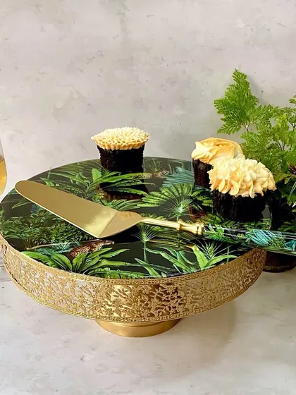 Elevate any celebration with our stunning Amazonia cake stand and server set. The lush, vibrant forest print and luxurious gold finish bring a touch of the tropics to your dessert presentation.