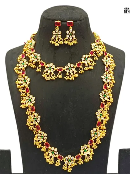 This floral-patterned necklace set with red and green stones is a versatile choice that can be paired with many different traditional outfits.