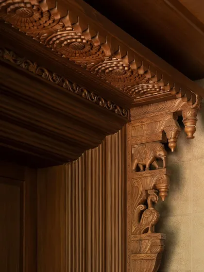 A detail of the intricate teak wood carving at the House of Gond. This close-up reveals the high level of craftsmanship, with traditional motifs of elephants and peacocks that pay tribute to Indian artistry.