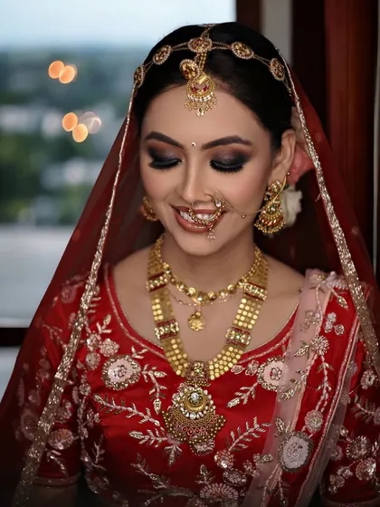 The perfect bridal smile. This look features a dramatic smokey eye, contoured cheeks, and a traditional matha patti, creating a timeless and graceful appearance.