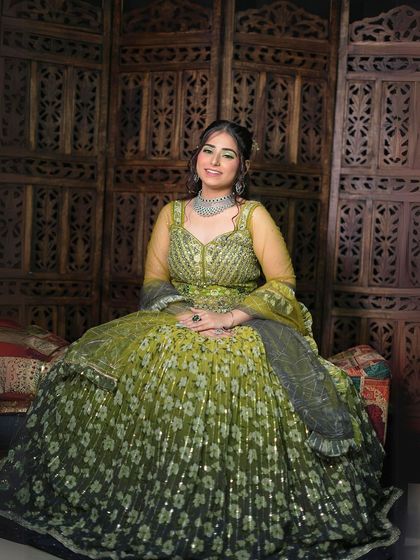 A seated portrait that shows the beautiful flare and floral pattern of the Anarkali.
