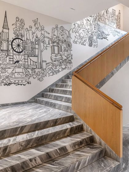 A detail of the staircase mural, showcasing whimsical characters and architectural landmarks.