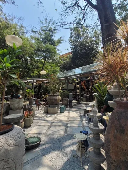 Another view of the main courtyard, filled with an abundance of garden artifacts and plants. The design creates a layered and textured experience, with something new to see at every turn.