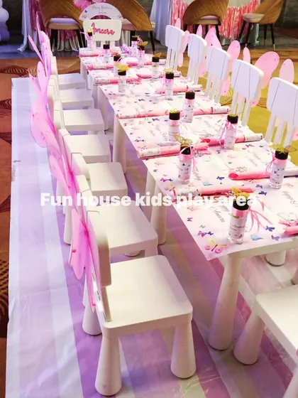 A beautiful fairy-themed party table setup. Our white chairs are adorned with delicate pink fairy wings, showing another creative way we customize our rentals to fit your vision.