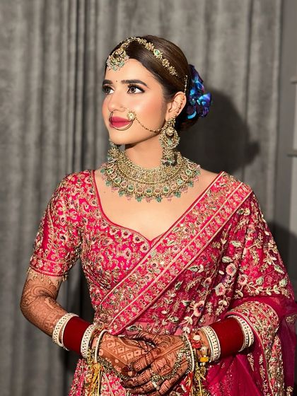 A closer look at this bride's regal profile. The bold lip and defined eyes are balanced with glowing skin, creating a look of pure elegance.