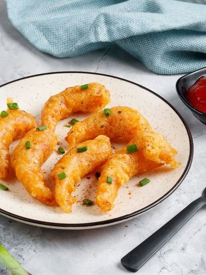 A plate of our crispy Fried Prawns, garnished with chopped spring onions. A simple, light, and delicious seafood starter.