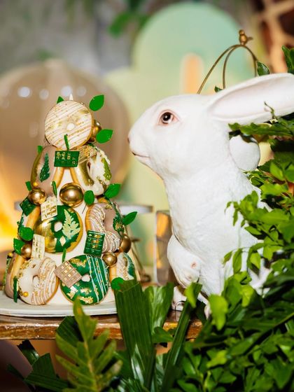 A creative donut tower and a rabbit prop from Eshaan's safari party. The treats are decorated with green icing and gold leaf to match the jungle theme.