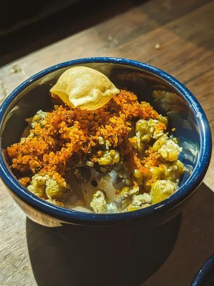 Kanji Payar, or rice congee with green gram, is the ultimate comfort food. I serve it here in a tasting bowl, topped with crispy papadum and a flavorful dry prawn chammandi. It’s a nutritious and flavorful appetizer.