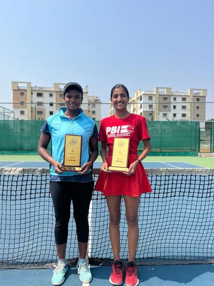 A full-length view of our doubles champions posing with their winner's plaques, showcasing the result of their perseverance and teamwork.