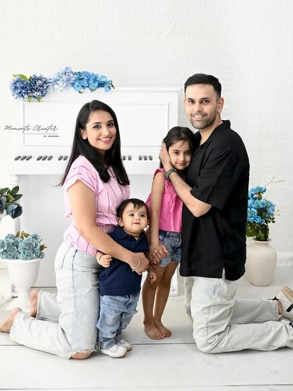 A sweet family huddle. This pose shows the close-knit bond of this family of four, creating an intimate and loving portrait.