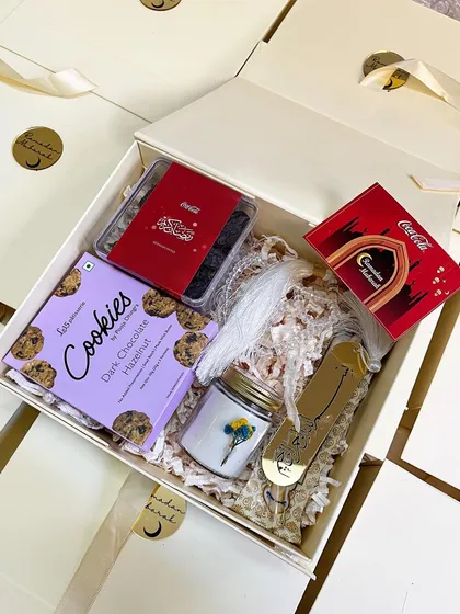 A premium Ramadan gift hamper curated for Coca-Cola. This beautiful box includes dark chocolate cookies, a scented candle, and a custom acrylic bookmark.