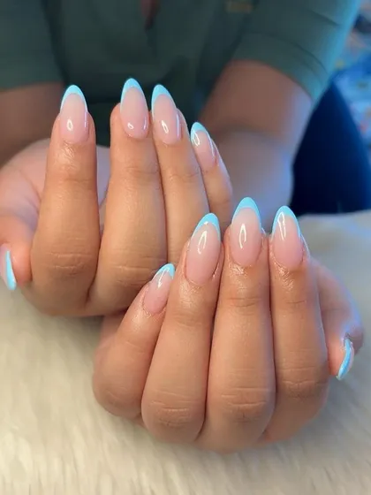 A fresh take on a classic. These flawless French nails feature a clean, sheer pink base and crisp baby blue tips on elegant, almond-shaped extensions.