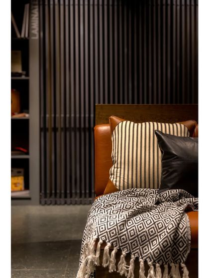 A cozy seating area with a leather couch, providing a comfortable spot for customers to relax and review samples.